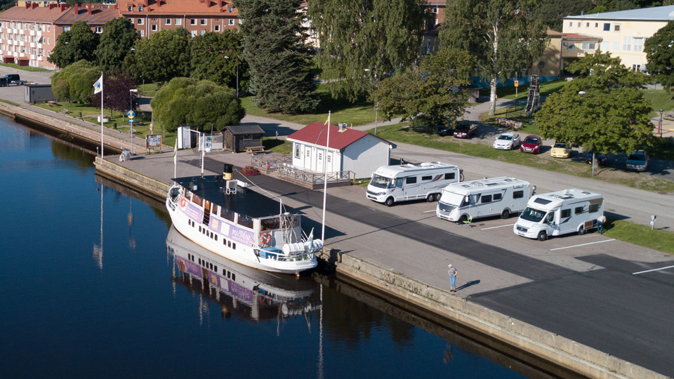 Hamn med turistbåt, husbilar och receptionshus