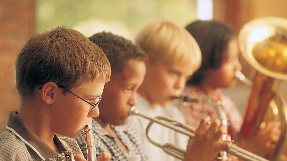 Fyra barn spelar blåsinstrument.